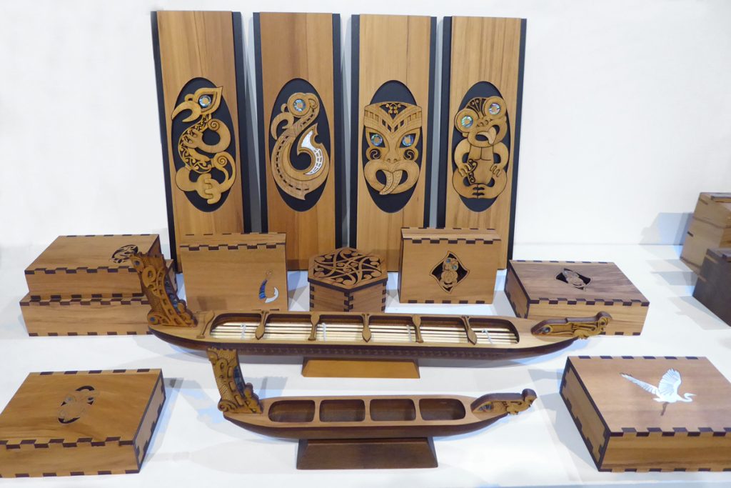 Wooden panels, waka and boxes with maori designs by Aeon Giftware