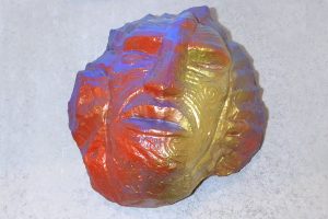 Maori tattooed head carved from rock and brightly painted, by Darcy Nicholas