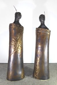 Ceramic figures of maori wearing cloaks by Fiona Bryant