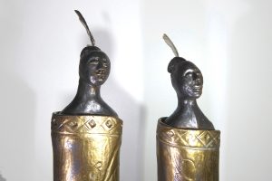 Ceramic figures of maori wearing cloaks by Fiona Bryant